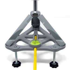 May include: A gray tripod with a silver central column and a white top. The tripod has three gray legs with textured grips and black adjustment knobs. A yellow rod extends from the center, and a level is visible.