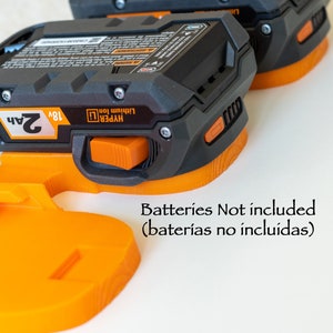 Puede incluir: Dos adaptadores de bater&iacute;a Hyper Lithium Ion de 18V en negro y naranja. Los adaptadores tienen un bot&oacute;n de liberaci&oacute;n naranja y est&aacute;n dise&ntilde;ados para bater&iacute;as de 2Ah. El texto "Batteries Not included" es visible.