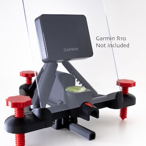 May include: A 3D printed black plastic mount with red knobs for adjusting the angle. A black Garmin R10 GPS device is mounted on top. The text "Garmin R10 Not included" is visible in the image.