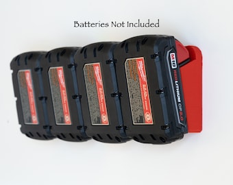 May include: A black battery holder with a red accent, designed to hold multiple M18 REDLITHIUM CP2.0 batteries. The holder is mounted on a white surface. The text "Batteries Not Included" is visible.