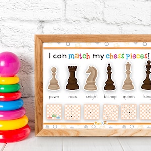 Op de afbeelding: Een kleurrijk stapelspeelgoed en een ingelijste educatieve print. De print toont schaakstukken met de tekst "I can match my chess pieces!" en namen van schaakstukken. Het stapelspeelgoed heeft een roze bal en diverse gekleurde ringen.
