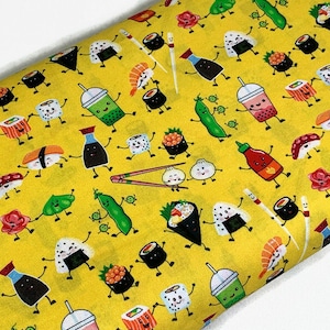 May include: Yellow fabric with a repeating pattern of sushi, soy sauce bottles, green tea, and chopsticks. The sushi is depicted as cartoon characters with smiling faces.