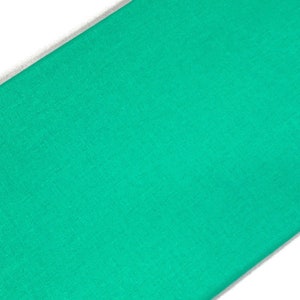 May include: A solid teal green fabric swatch. The fabric has a smooth, even texture.