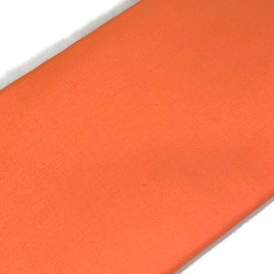 May include: A solid piece of fabric in a bright orange color. The fabric has a soft, fuzzy texture.