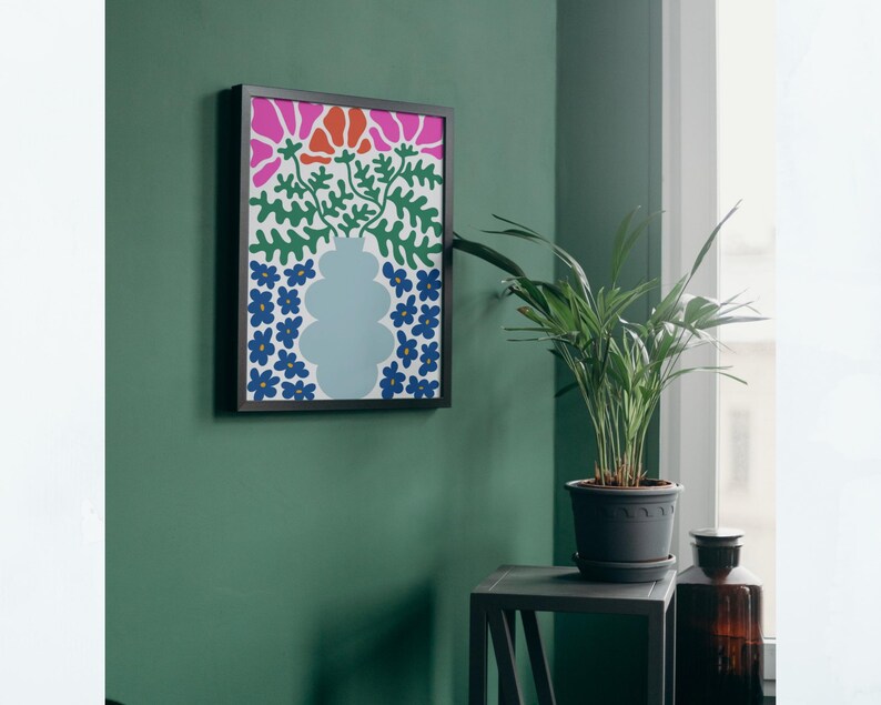 Puede incluir: Una impresi&oacute;n enmarcada de un dise&ntilde;o floral abstracto colorido con flores rosas, azules y verdes en un jarr&oacute;n. El jarr&oacute;n es azul claro y el fondo es blanco.