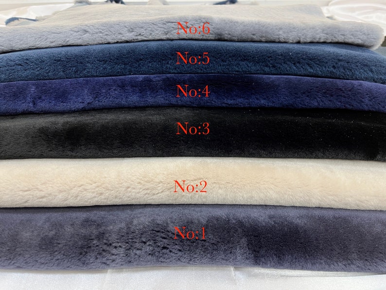 May include: Six fabric swatches stacked on top of each other. The swatches are numbered from 1 to 6. The swatches are in the following colors: light blue, dark blue, navy blue, black, cream, and light gray.