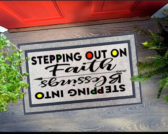May include: A gray doormat with black text that reads "Stepping into blessings! Stepping out on Faith". The text is decorated with colorful dots and an arrow.