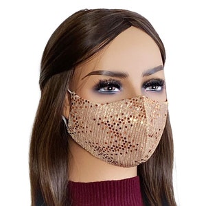 May include: A gold face mask with brown sequins. The mask is made of a soft, comfortable material and has adjustable ear loops.