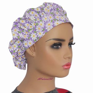 a mannequin head wearing a head wrap with flowers on it