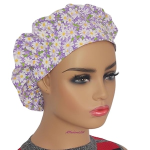 a mannequin head wearing a purple and white flower turban