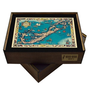 May include: A wooden box with a vintage map of the Florida Keys inside. The map is printed on paper and features a blue background with yellow and red accents. The box is made of dark wood and has a black felt lining. The box has a label on the front that says "Wood Work What A".