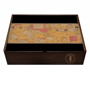 May include: A wooden puzzle box with a vintage world map design. The map features a yellow background with pink and brown accents, and is set against a black interior. The box has a dark brown finish and a circular logo on the front.