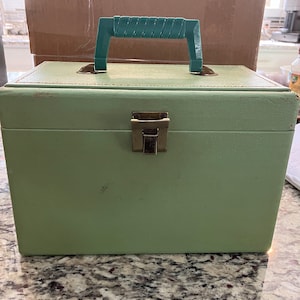 May include: A vintage green vinyl record carrying case with a brass latch and a green plastic handle.