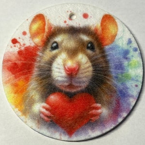 May include: A brown rat holding a red heart in its paws, surrounded by colourful watercolour splatters.