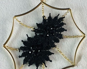 May include: Gold spiderweb-shaped earrings with black lace accents.