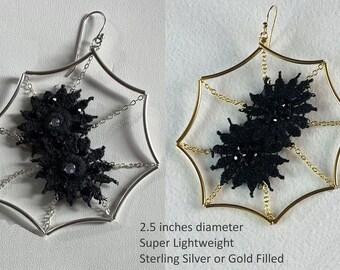 May include: A pair of 2.5 inch diameter earrings featuring a black lace design in a silver or gold filled spiderweb frame.  Super lightweight.