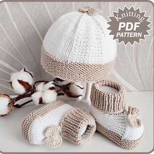 May include: A knitted baby set in cream and beige. The set includes a beanie hat with a small bow, and matching booties. The text "Knitting PDF Pattern" is in a starburst shape. The set is displayed on a white surface.
