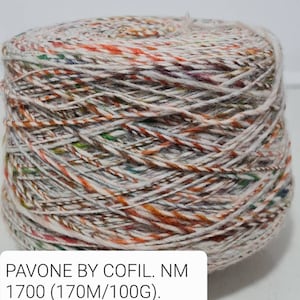 Może przedstawiać: Motka włóczki w połączeniu kolorów białego, pomarańczowego i zielonego. Włóczka jest oznaczona "PAVONE BY COFIL. NM 1700 (170M/100G). Grigio/pasta. 1200 g."