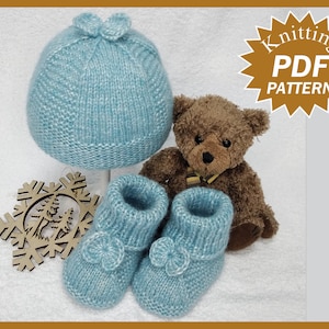 May include: Knitting pattern PDF for a baby hat and booties. The hat and booties are light blue and have a flower detail. A brown teddy bear is in the background.