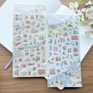 May include: Two sticker sheets featuring illustrated city maps with buildings, vehicles, and people. The stickers have a light blue and beige color scheme, with the text "machi map" at the top. The stickers are on a white background.