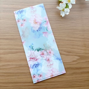 May include: A light blue envelope with a floral pattern featuring pink and blue flowers. The envelope has a white background and a delicate pink border.