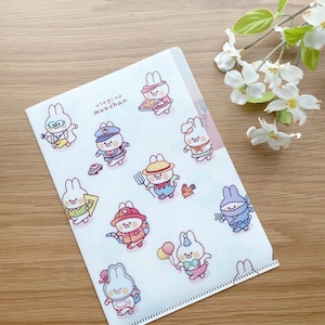 May include: A clear plastic folder with a white background and a repeating pattern of cute cartoon bunnies dressed in different costumes. The text "usagi no muuchan" is printed in the top left corner of the folder.