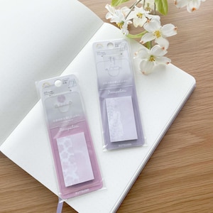 May include: Two packs of pastel purple sticky notes with a floral pattern. The sticky notes are packaged in clear plastic with a white label that says "Petitpalette" and "KUTSUWA".