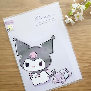 May include: A clear plastic file folder with a Kuromi character design. The design features Kuromi, a black cat with a pink skull and bow, and a small purple and white character. The text on the folder reads "Kuromi It's a little things in life that put the happy in every day."