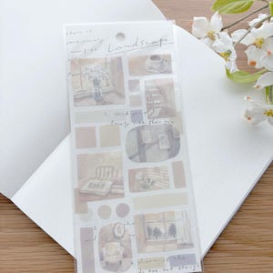 May include: A clear sticker sheet with watercolor illustrations of interior scenes, including a window, chair, and coffee cup. The word "Landscape" is handwritten on the sheet, along with other handwritten phrases. The sticker sheet is on a white dotted paper.