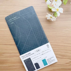 May include: A blue file folder with a map pattern and the text "FILE FOLDER with envelope type pocket SLIM" on the front. The folder is open to reveal a smaller pocket on the inside. The text "FILE FOLDER with envelope type pocket SLIM" is also on the inside of the folder. The text "コンパクトなA4三つ折りサイズでふた付きポケットも備えた2ポケットファイルホルダー" is printed on the inside of the folder.