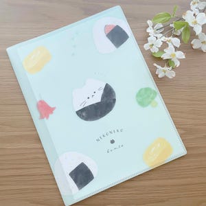 May include: A light blue plastic folder with a cat and onigiri (Japanese rice balls) design. The folder has the text "NEKONeko bento" printed on it.