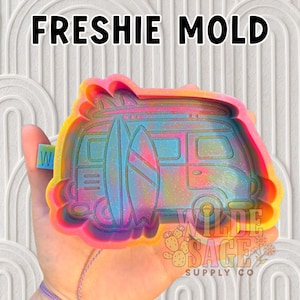 May include: A colorful resin mold with the text "FRESHIE MOLD" at the top. The mold features a van with surfboards, in shades of pink, blue, yellow, and orange. The Wilde Sage Supply Co. logo is visible.