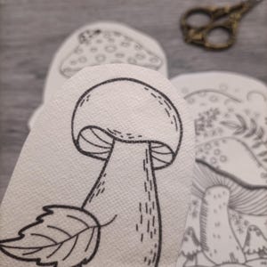 K&ouml;nnte beinhalten: Eine Schwarzwei&szlig;-Zeichnung eines Pilzes mit einem Blatt am Stiel. Der Pilz hat eine abgerundete Kappe mit einer strukturierten Oberfl&auml;che und einen langen, schlanken Stiel. Das Blatt ist einfach und hat eine spitze Spitze.