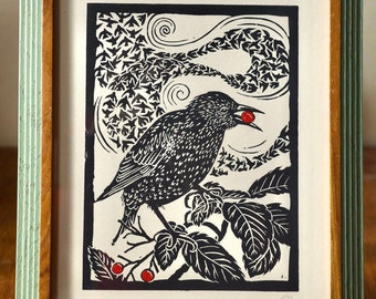 May include: Black and white linocut print of a bird with a red berry in its beak, perched on a branch with leaves. The background is a swirling pattern of leaves.