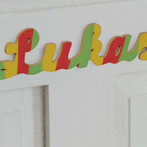 Placa com nome para porta de quarto infantil, multicolorida, em madeira, autoadesiva, a partir de 15 euros (dependendo do comprimento do nome)