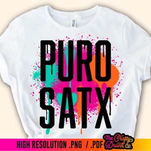 May include: White t-shirt with a black graphic design that says "PURO SATX" in a spray paint style with pink, orange, and turquoise accents.