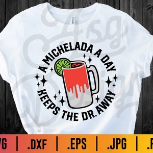 Könnte beinhalten: Ein weißes T-Shirt mit einem schwarzen Kreisdesign, das ein Glas Michelada mit einem Limettenkeil und dem Text "A Michelada a Day Keeps the Dr. Away" zeigt.