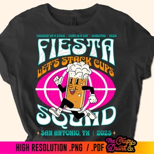 May include: Black t-shirt with a colorful graphic design featuring a cartoon beer mug running with the text "Fiesta Let's Stack Cups Sound" and "San Antonio, TX | 2025".