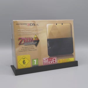 May include: A Nintendo 3DS XL handheld game console in a gold and black limited edition box. The packaging features The Legend of Zelda: A Link Between Worlds branding, a USK 6 age rating, and a 90% bigger screens graphic on the front display.