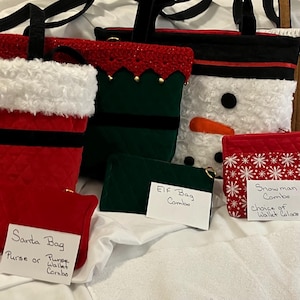 May include: A collection of Christmas-themed bags and wallets. Designs include Santa, an elf, a snowman, and a gingerbread house. The Santa bag is red with a white trim and black belt. The snowman bag has a carrot nose.