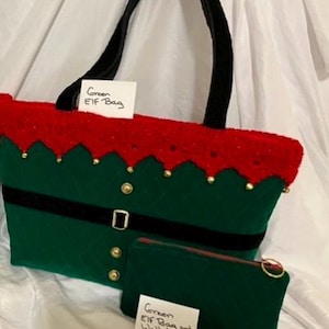 May include: A green Elf bag with a red top and black handle, and a matching green wallet. The bag has a black belt with a buckle and gold buttons. The text on the bag says "Green ELF Bag". The wallet says "Green ELF Bag and Wallet Combo".
