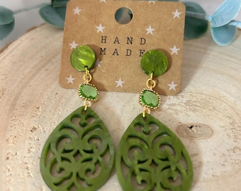 May include: Green and gold dangle earrings with a filigree design. The earrings are handmade and feature a green stone accent.