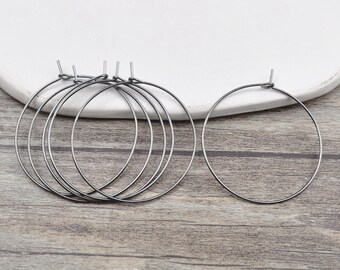 May include: Set of six black hoop earrings. The hoops are made of metal and have a simple, circular design.