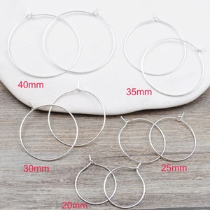 May include: Silver hoop earrings in various sizes: 20mm, 25mm, 30mm, 35mm, and 40mm.