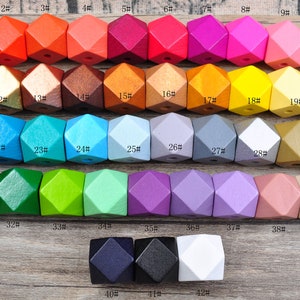 Könnte beinhalten: Ein Satz mit 42 Holzperlen in verschiedenen Farben, jede Perle ist eine geometrische Form mit 12 Seiten. Die Perlen sind von 1 bis 42 nummeriert.