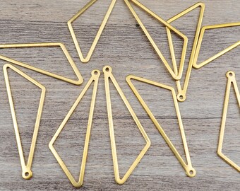 May include: A set of ten gold-toned metal geometric shapes. The shapes are all triangles with rounded corners and have a hole at each point. The shapes are arranged in a circular pattern on a wooden surface.