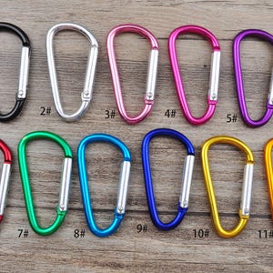 May include: Eleven different coloured metal keyrings with a D-shaped ring. The keyrings are numbered 1 through 11.