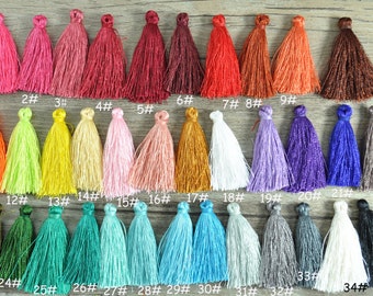 May include: Thirty-five colorful tassels in various shades of red, pink, orange, yellow, green, blue, purple, brown, and white. The tassels are arranged in rows and numbered 1 through 35.
