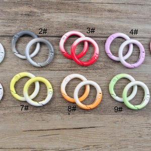 Pode incluir: Dez pares de chaveiros de metal de dupla volta coloridos com um design degradê. Os chaveiros são numerados de 1 a 10.