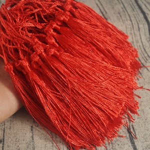 Puede incluir: Un montón de flecos rojos, perfectos para añadir un toque de elegancia a tus proyectos de manualidades.